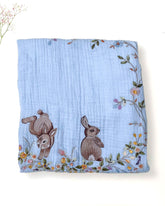 Soft fairytale blue bunny dohar for baby with delicate embroidery featuring two bunnies surrounded by a floral wreath. Made from lightweight, breathable fabric with a satin border—perfect for cozy naps and gentle on baby’s skin.