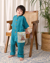 Boy wearing LAAD peacock green cotton bandhgala jumpsuit with wooden buttons and an embroidered bear patch fun large pocket.