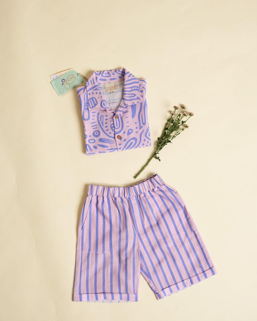 Aline fun print half-sleeve ameba shirt featuring wooden buttons and stylish strips Bermuda shorts. a perfect co-ord set of kids summer shirt sand shorts