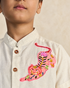 Arlo Co-ord by LAADINDIA — boys beige cotton-linen co-ord set featuring a mandarin collar shirt with wooden button closure, handcrafted pink tiger appliqué embroidery, and matching tailored shorts