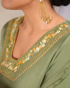 Afghani moss Green designer kaftan set with V-neckline and intricate hand embroidery, paired with Afghani pants featuring ankle-length hem embroidery and zip opening – handcrafted festive ethnic wear for women by Lady Laad