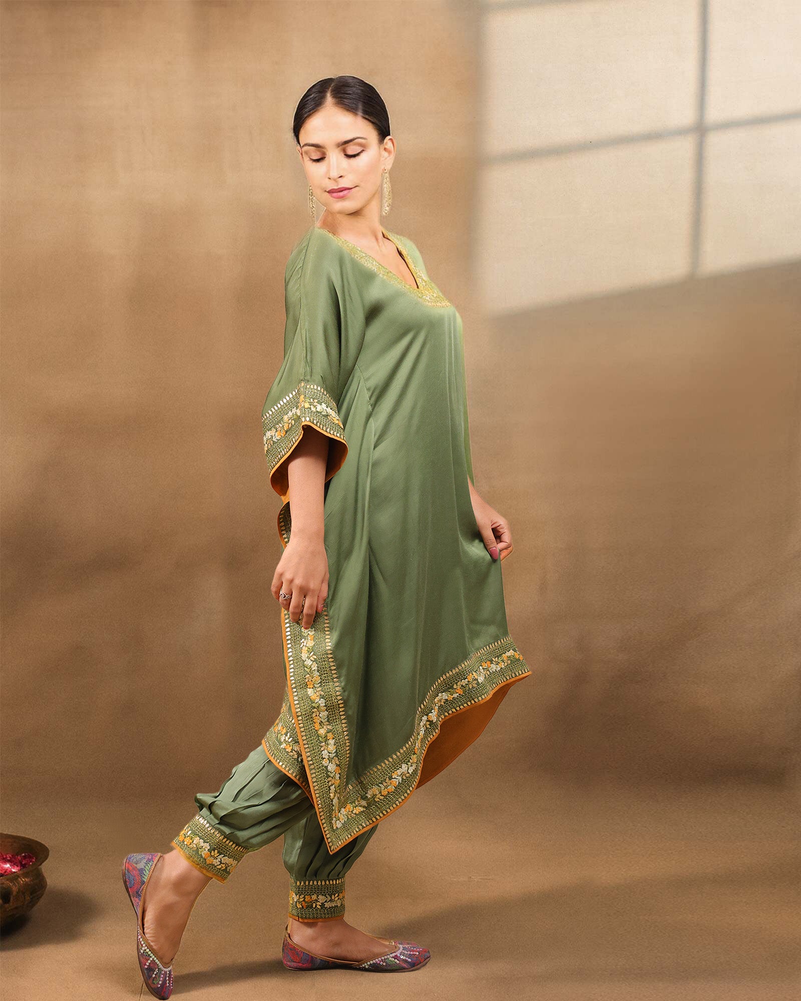 Afghani moss Green designer kaftan set with V-neckline and intricate hand embroidery, paired with Afghani pants featuring ankle-length hem embroidery and zip opening – handcrafted festive ethnic wear for women by Lady Laad