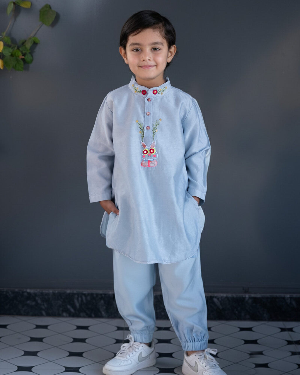 Baby blue bun bandhgala kurta pyjama set   features intricate hand embroidery around the placket and collar with a delightful Bluey motif and shimmering mirror glare details. Fun, colorful buttons add a playful touch, while solid elastic pyjamas ensure comfort and a secure fit
