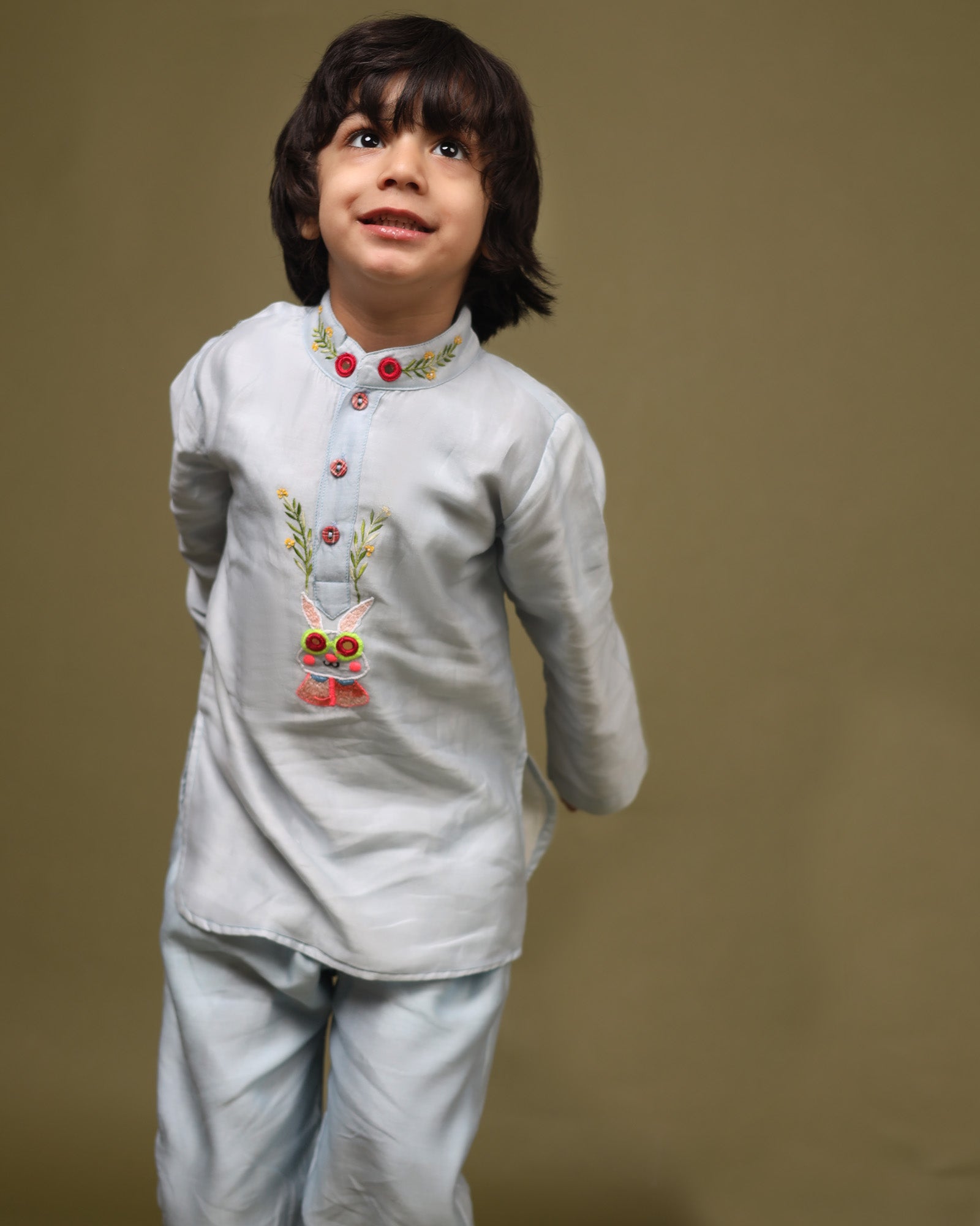 Baby blue bun bandhgala kurta pyjama set   features intricate hand embroidery around the placket and collar with a delightful Bluey motif and shimmering mirror glare details. Fun, colorful buttons add a playful touch, while solid elastic pyjamas ensure comfort and a secure fit