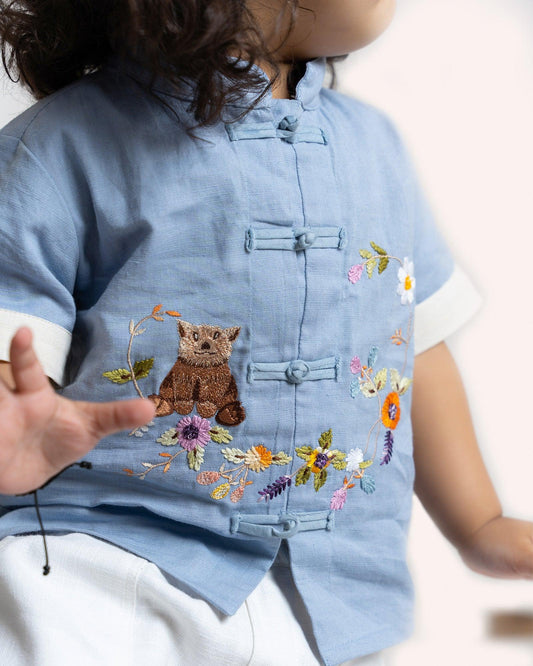 Keep it cool with our Blue Ted Summer Shirt, crafted from breathable fabric for comfort. A mandarin collar, loop buttons, and teddy embroidery add playful charm.
