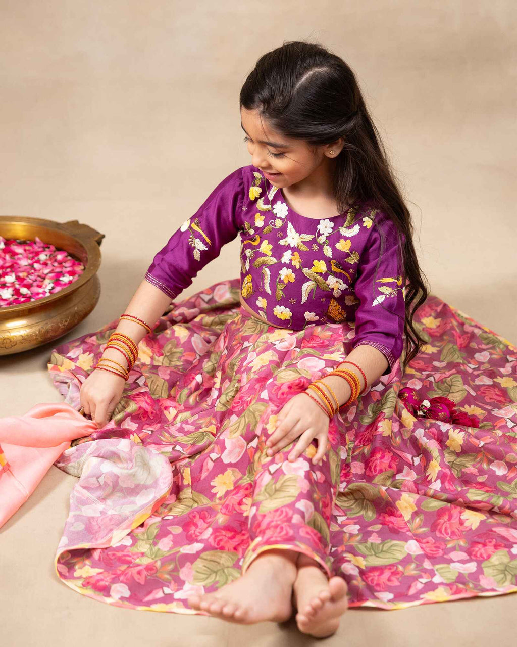 Little girl in purple lehenga  choli with dupatta .This  bulbul voilet bagh lehenga with dupatta features  floral print set with  purple embroidered blouse, purple lehenga choli with dupatta featuring floral charm ,hand  embroidery for girls festive wear- occasions like weddings, pooja and family functions.