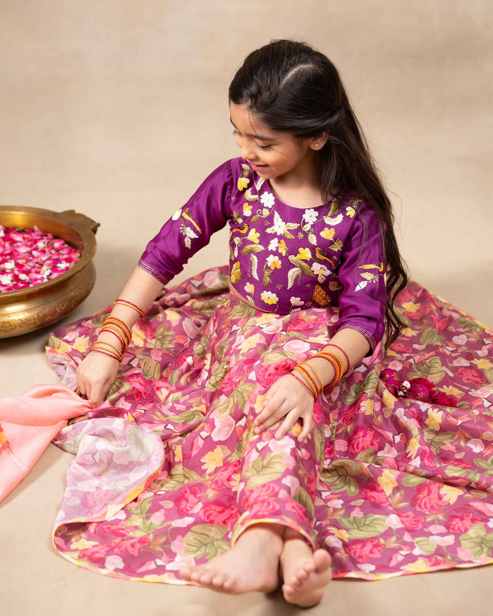Little girl in purple lehenga  choli with dupatta .This  bulbul voilet bagh lehenga with dupatta features  floral print set with  purple embroidered blouse, purple lehenga choli with dupatta featuring floral charm ,hand  embroidery for girls festive wear- occasions like weddings, pooja and family functions.