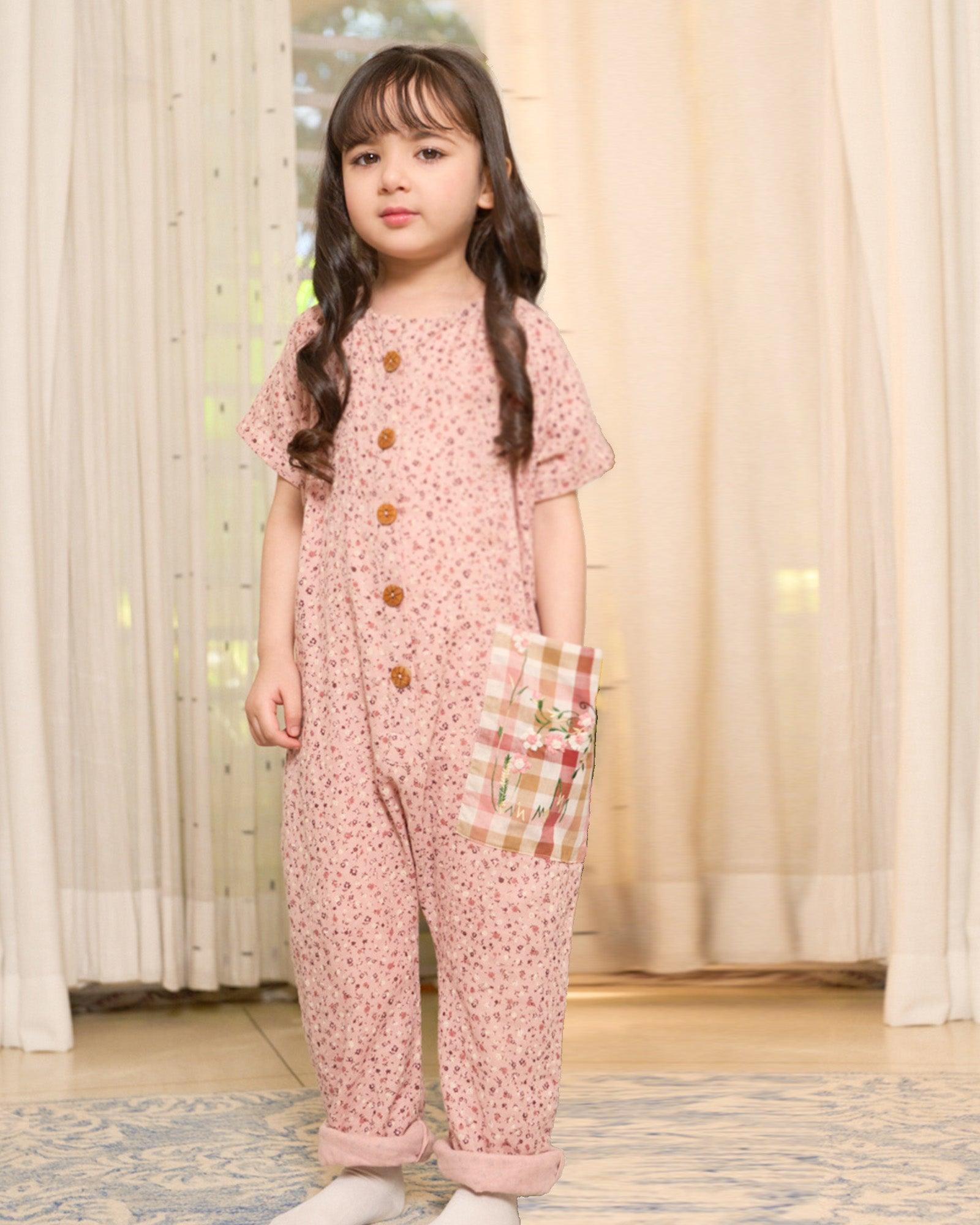 Laad`s child is wearing the adorable daisy onesie boasts a comfy round neck & wooden button front. A spacious pocket is adorned with charming hand-embroidered flowers & butterflies. Super soft fabric & a relaxed fit keep your little one happy & comfy all trip long!