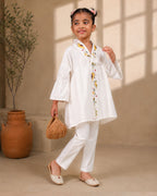 A young girl modeling a white kimono  flower look co-ord   set with colorful floral bird embroidery down the front placket by laandindia.com