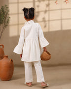 A young girl modeling a white kimono  flower look co-ord   set with colorful floral bird embroidery down the front placket by laandindia.com