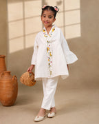 A young girl modeling a white kimono  flower look co-ord   set with colorful floral bird embroidery down the front placket by laandindia.com