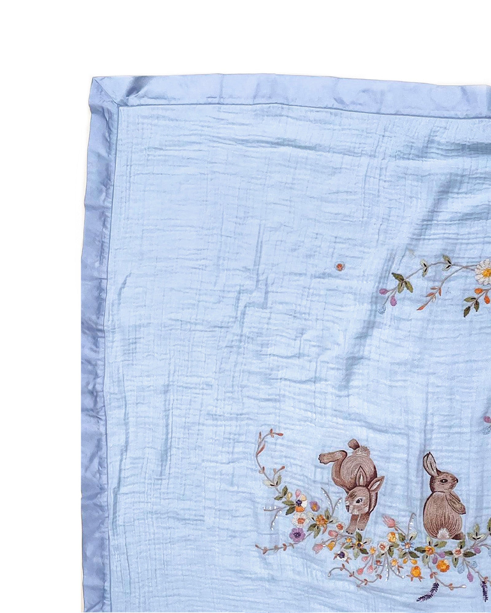 Soft fairytale blue bunny dohar for baby with delicate embroidery featuring two bunnies surrounded by a floral wreath. Made from lightweight, breathable fabric with a satin border—perfect for cozy naps and gentle on baby’s skin.