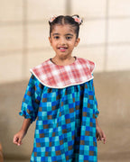 Girl wearing laad`s blue checkered party  dress , girl blue bell dress feature a red plaid Peter Pan collar and lace trim at the hem. perfect travel , occasion wear