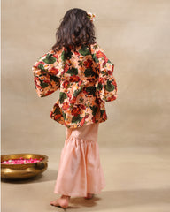 Girl wearing GLUBAGH PEACH SHARARA a handcrafted floral red kimono style top with embroidered neckline and flared ivory sharara pants – ethnic festive kidswear by LAAD