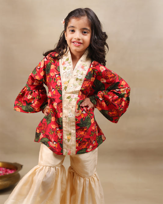 Girl wearing a handcrafted floral red kimono style top with embroidered neckline and flared ivory sharara pants – ethnic festive kidswear by LAAD