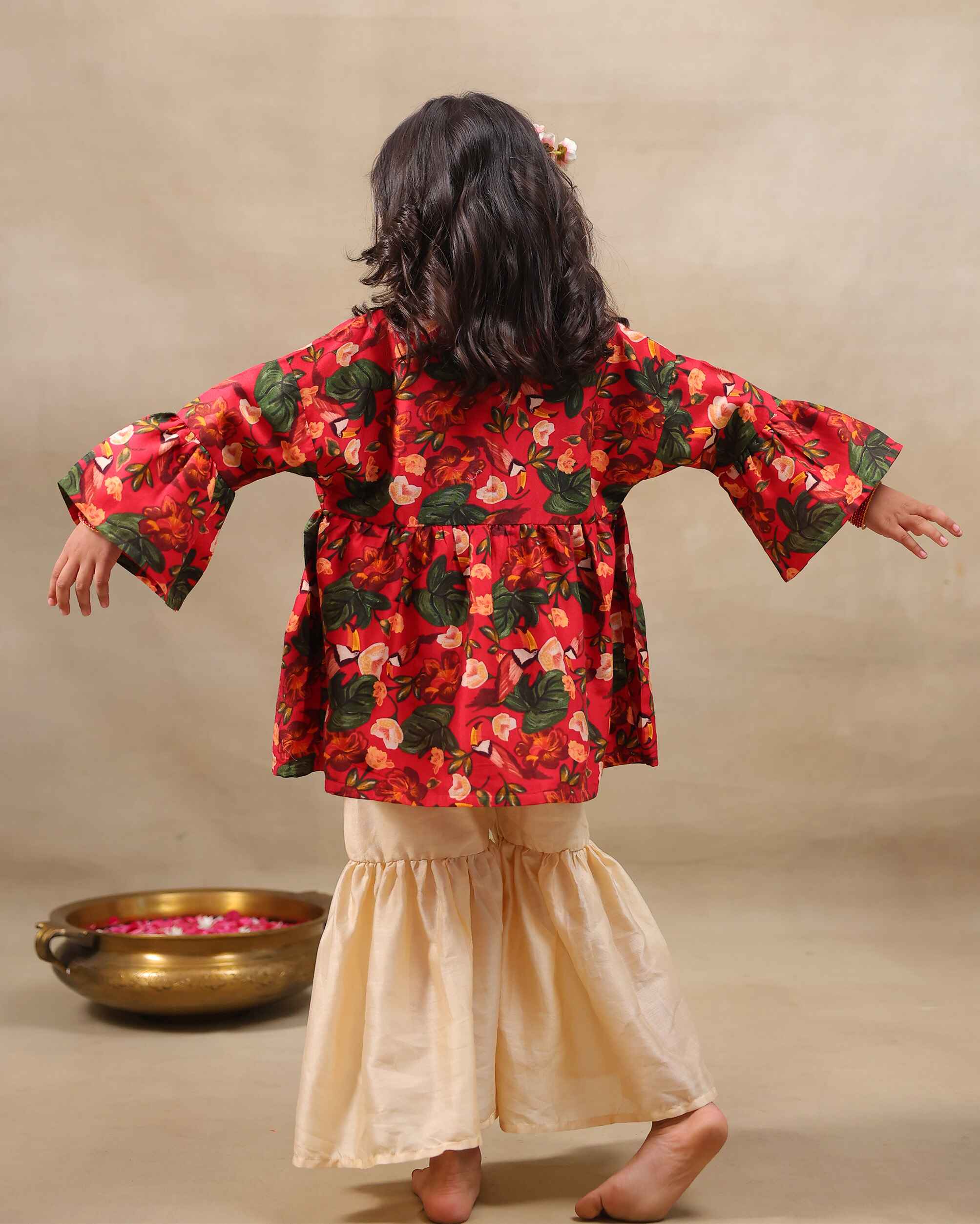 Girl wearing a handcrafted floral red kimono style party wear sharara with embroidered neckline and paired with  flared ivory sharara pants – perfect girls festive kidswear, occasion and celebration wear by LAADindia.