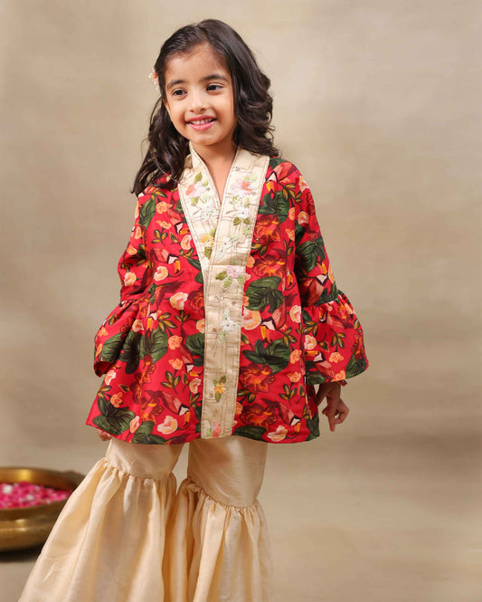 Girl wearing a handcrafted floral red kimono style party wear sharara with embroidered neckline and paired with  flared ivory sharara pants – perfect girls festive kidswear, occasion and celebration wear by LAADindia.