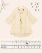 Little girl in a white hand-embroidered A-line kids party dress with flared sleeves and colorful bird and floral detailing, holding a wicker basket.