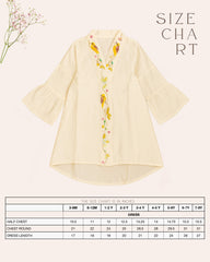 Little girl in a white hand-embroidered A-line dress with flared sleeves and colorful bird and floral detailing, holding a wicker basket.