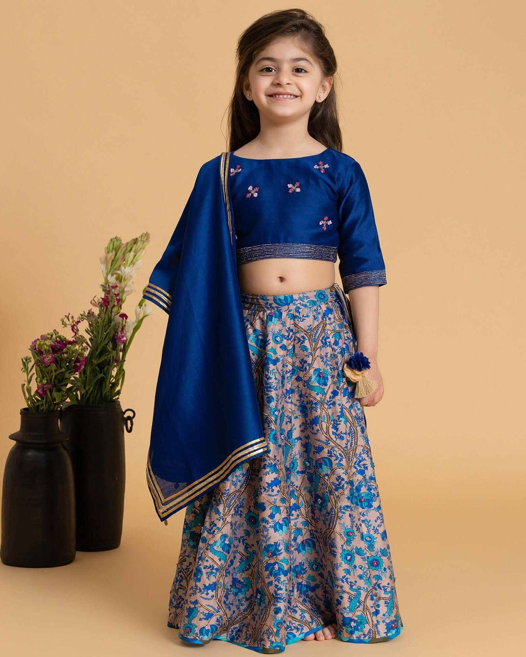 Girl in a midnite blue Midnite Phulwari lehenga embroidered blouse with intricate detailing, paired with a floral printed kids lehenga choli and dupatta with a gold border.