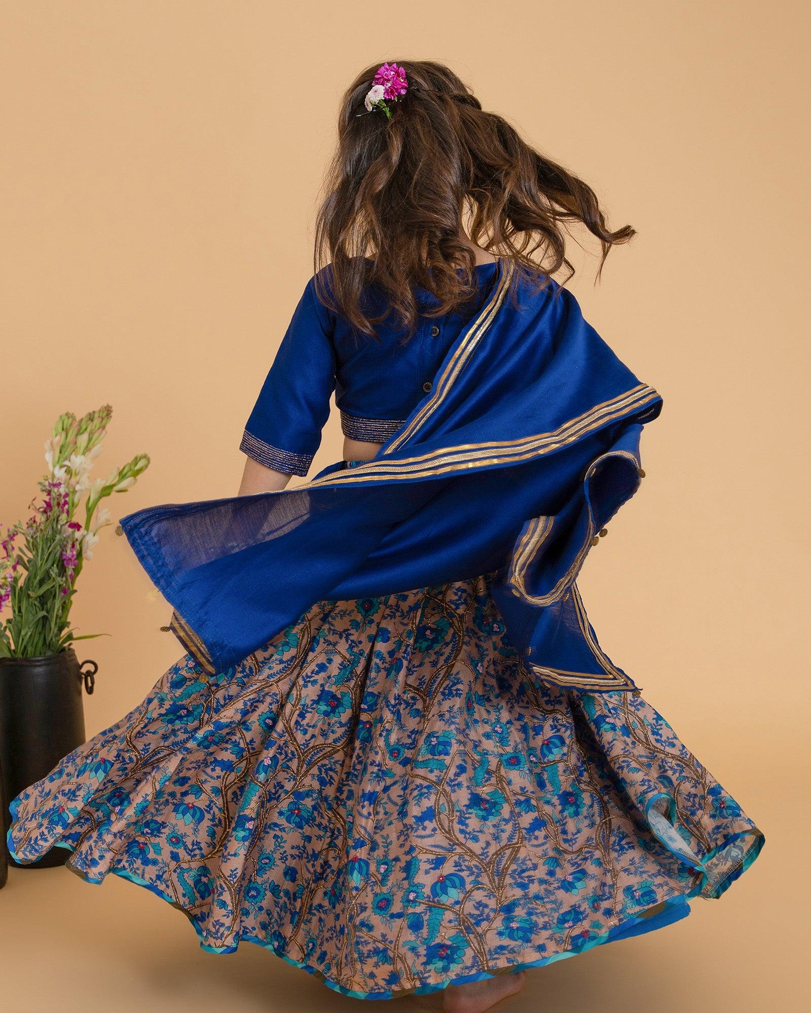 Dress your little one in the luxury of Midnite Phulwari lehenga, a timeless masterpiece. Three-piece set includes skirt, blouse, and dupatta. Crafted from silk chanderi for elegance and comfort. Intricate hand-embroidery and badla work adorn the blouse and skirt. 