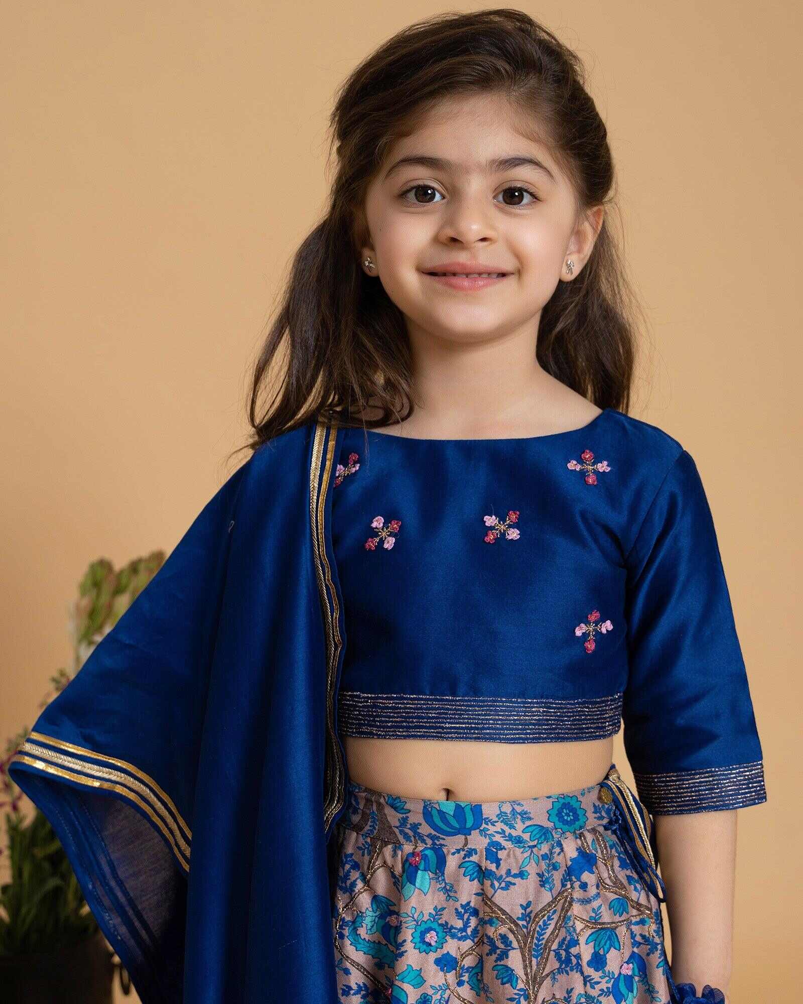 Girl in a midnite blue Midnite Phulwari lehenga embroidered blouse with intricate detailing, paired with a floral printed kids lehenga choli and dupatta with a gold border.