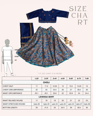 Girl in a royal blue Midnite Phulwari lehenga embroidered blouse with intricate detailing, paired with a floral printed lehenga and a matching dupatta with a gold border.