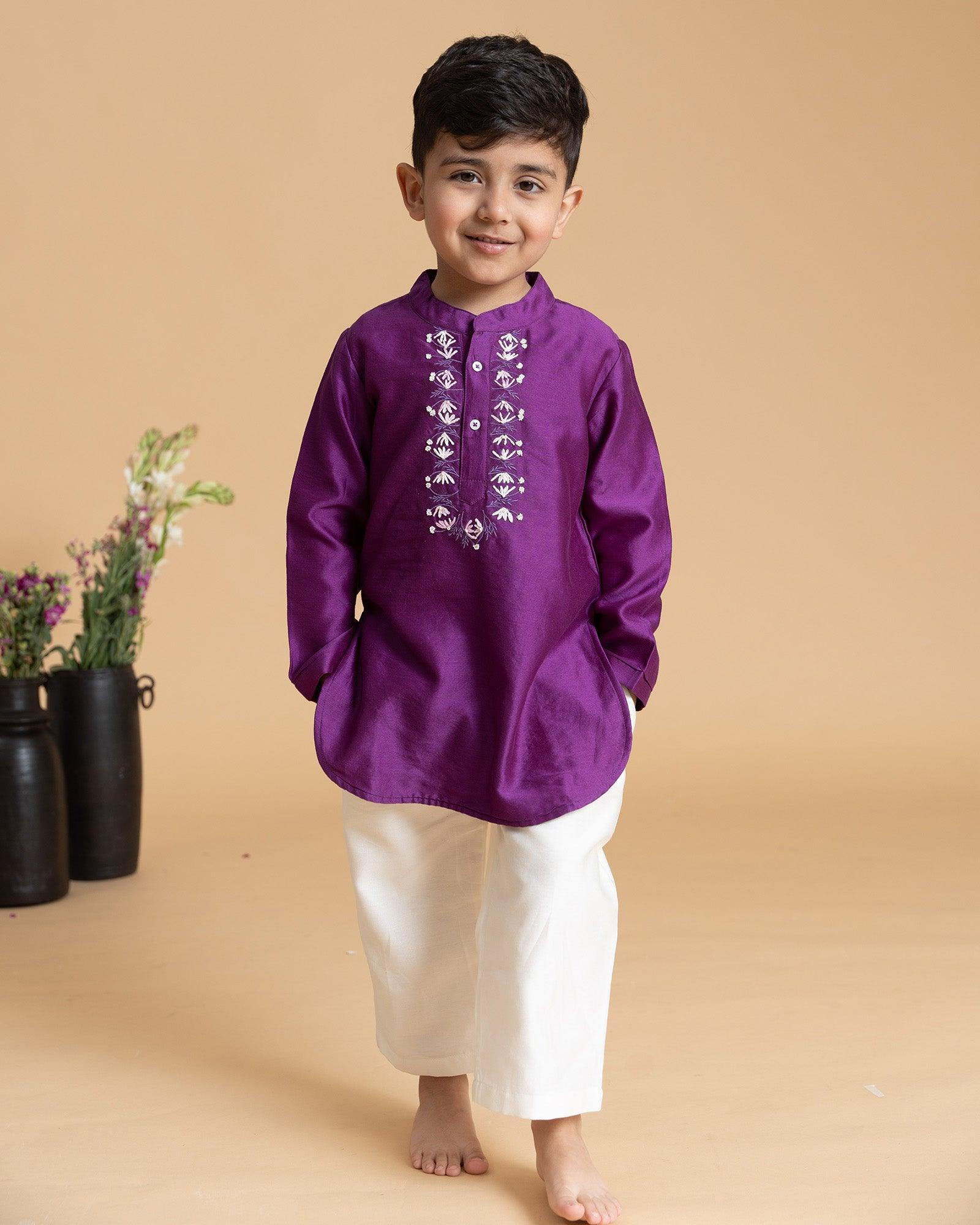 laad`s kid in japanese voilet kurta with embroideret  details on placket, paired  with off white trousers.