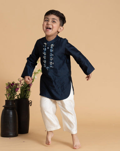 laad`s kid in marine blue kurta with embroideret  details on placket, paired  with off white trousers