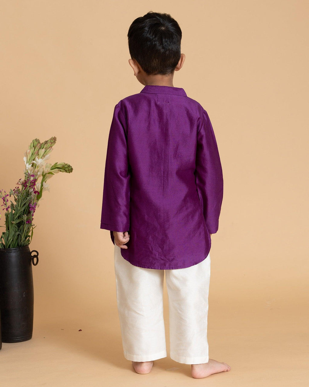 laad`s kid in japanese voilet kurta with embroideret  details on placket, paired  with off white trousers.