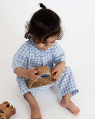 A stylish blue-and-white gingham romper featuring a collared neckline for a polished look. Designed with a front snap-button closure for easy dressing and a patch pocket with fine detailing for a playful touch perfect kidswear.