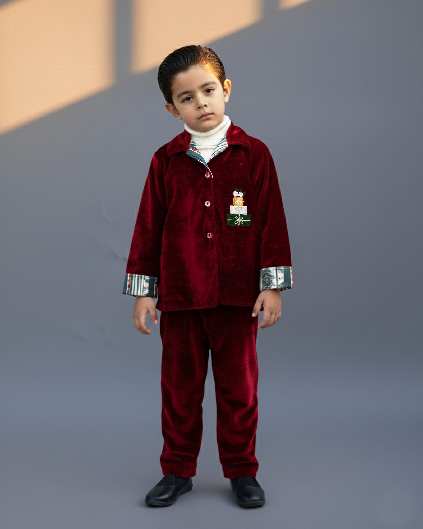 redvelvet co-ord set by LAADINDIA.com, featuring a child dressed in a red velvet co-ord with  embroidery, front-open top with contrast check cuffs, and matching trousers for winter occasion wear.