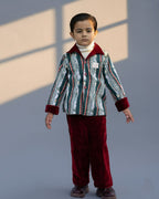 redvelvet co-ord set by LAADINDIA.com, featuring a child dressed in a red velvet co-ord with  embroidery, front-open top with contrast check cuffs, and matching trousers for winter occasion wear.