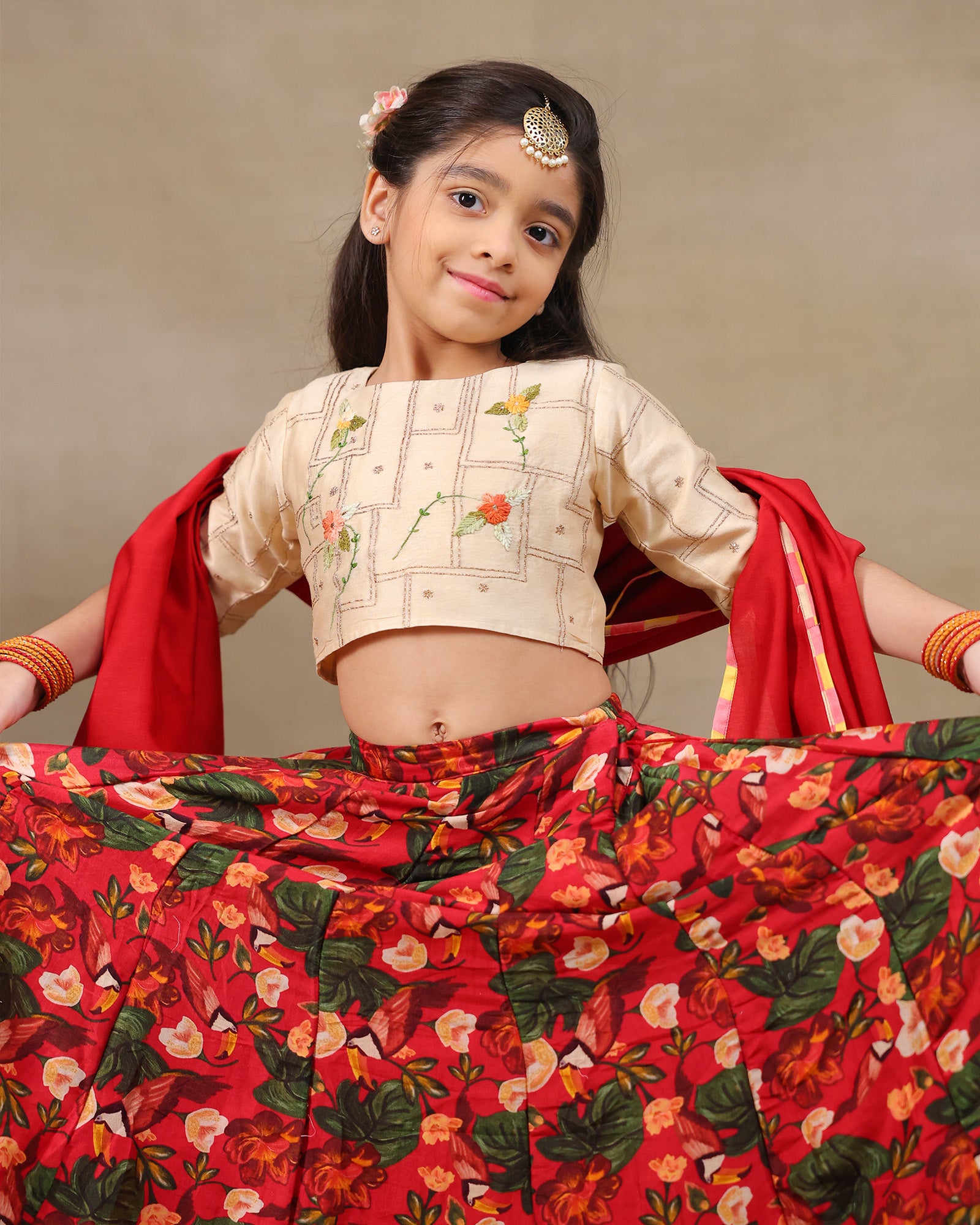 Young girl wearing LAAD’s floral red rose lehenga set with embroidered blouse and dupatta – festive ethnic wear for kids, perfect for weddings and celebrations.