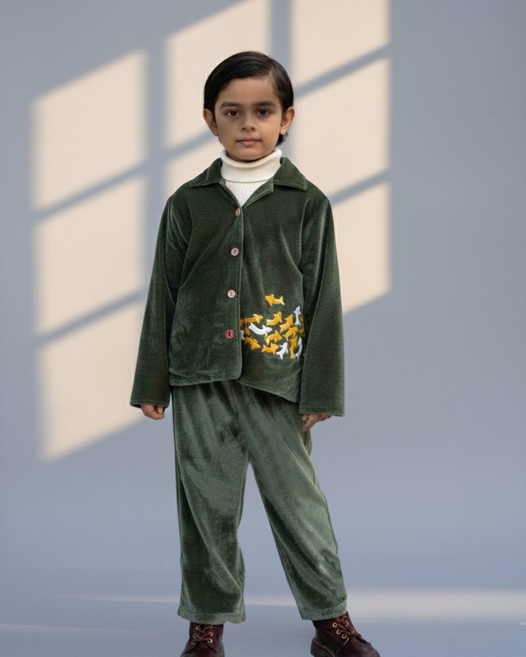 sage shoal co-ord set by LAADINDIA.com, featuring a child dressed in a navy blue velvet co-ord with floating fish embroidery, front-open top with contrast check cuffs, and matching trousers for winter festive wear.
