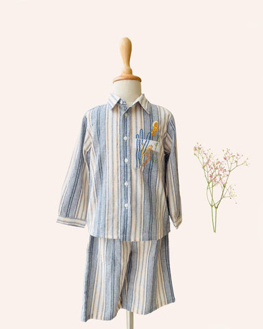 laad`s Kids' striped co-ord set with a long-sleeve shirt and shorts, featuring soft beige and gray tones. Embroidered seahorse detail adds a playful touch. Lightweight, breathable fabric for all-day comfort.