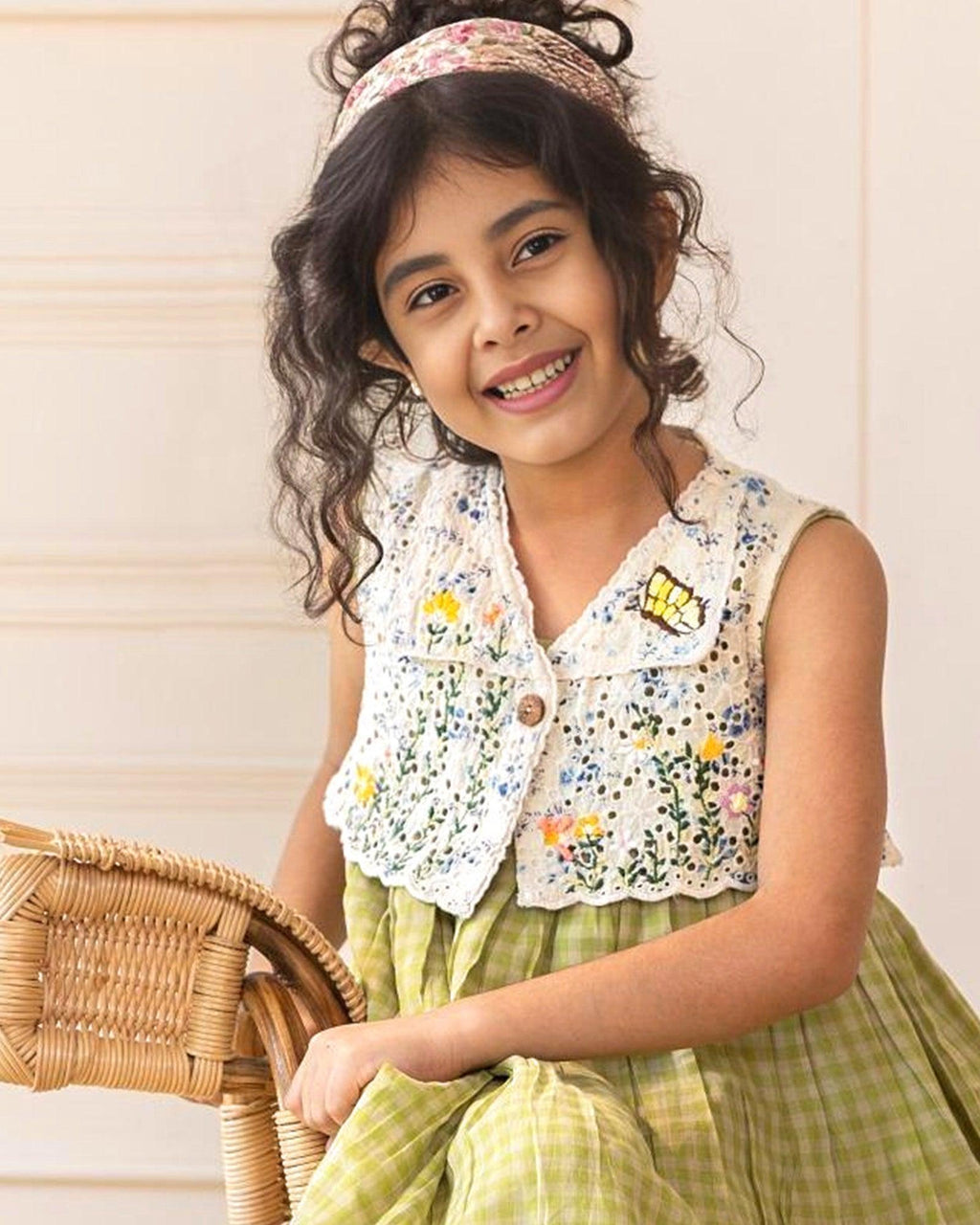 LAAD`S kid in Titalee moss green dress by Laad India, featuring delicate floral embroidery, an eyelet lace bodice, and a gingham checkered dress. A perfect blend of vintage elegance and modern comfort for your little one