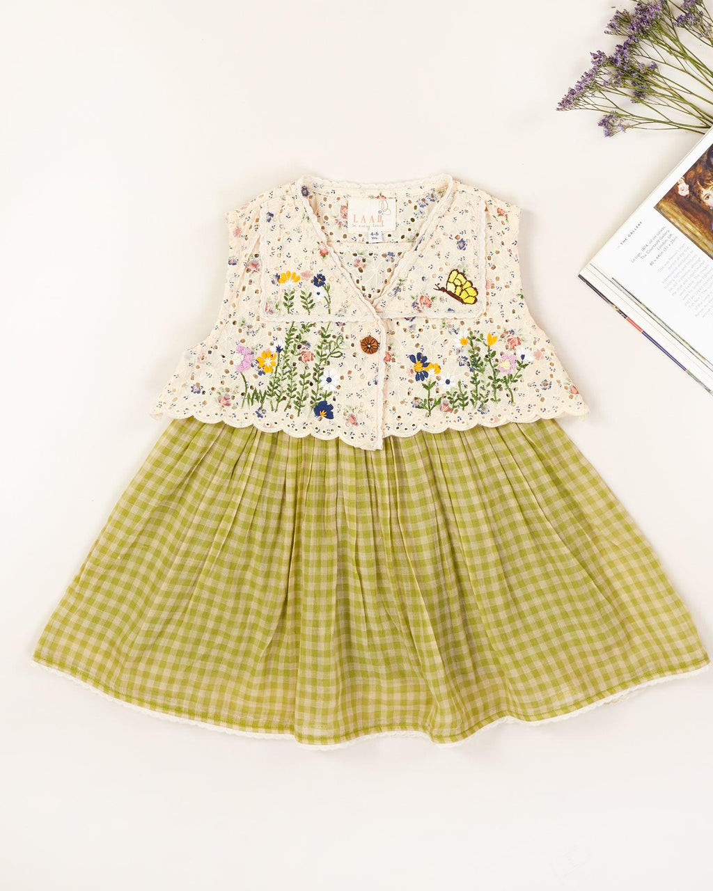 LAAD`S kid in Titalee moss green dress by Laad India, featuring delicate floral embroidery, an eyelet lace bodice, and a gingham checkered dress. A perfect blend of vintage elegance and modern comfort for your little one