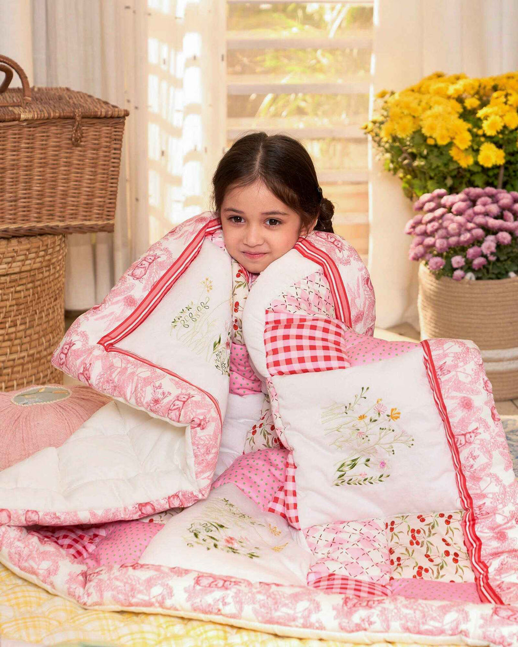 laad`s girl wearing white Rabit quilt features playful rabbits & vibrant scarlet for a touch of magic. Soft cotton & cozy fiber filling for ultimate comfort. 