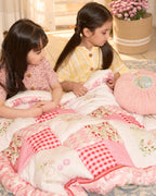 laad`s girl wearing white Rabit quilt features playful rabbits & vibrant scarlet for a touch of magic. Soft cotton & cozy fiber filling for ultimate comfort. 