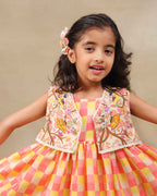Girl wearing the Zinnia party wear DRESS featuring a vibrant checkered kurta with embroidered and printed jacket detailing , perfect for festive occasions and birthday party