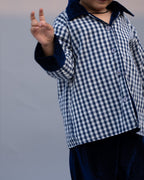 Midnite Shoal co-ord set by LAADINDIA.com, featuring a child dressed in a navy blue velvet co-ord with floating fish embroidery, front-open top with contrast check cuffs, and matching trousers for winter festive wear.