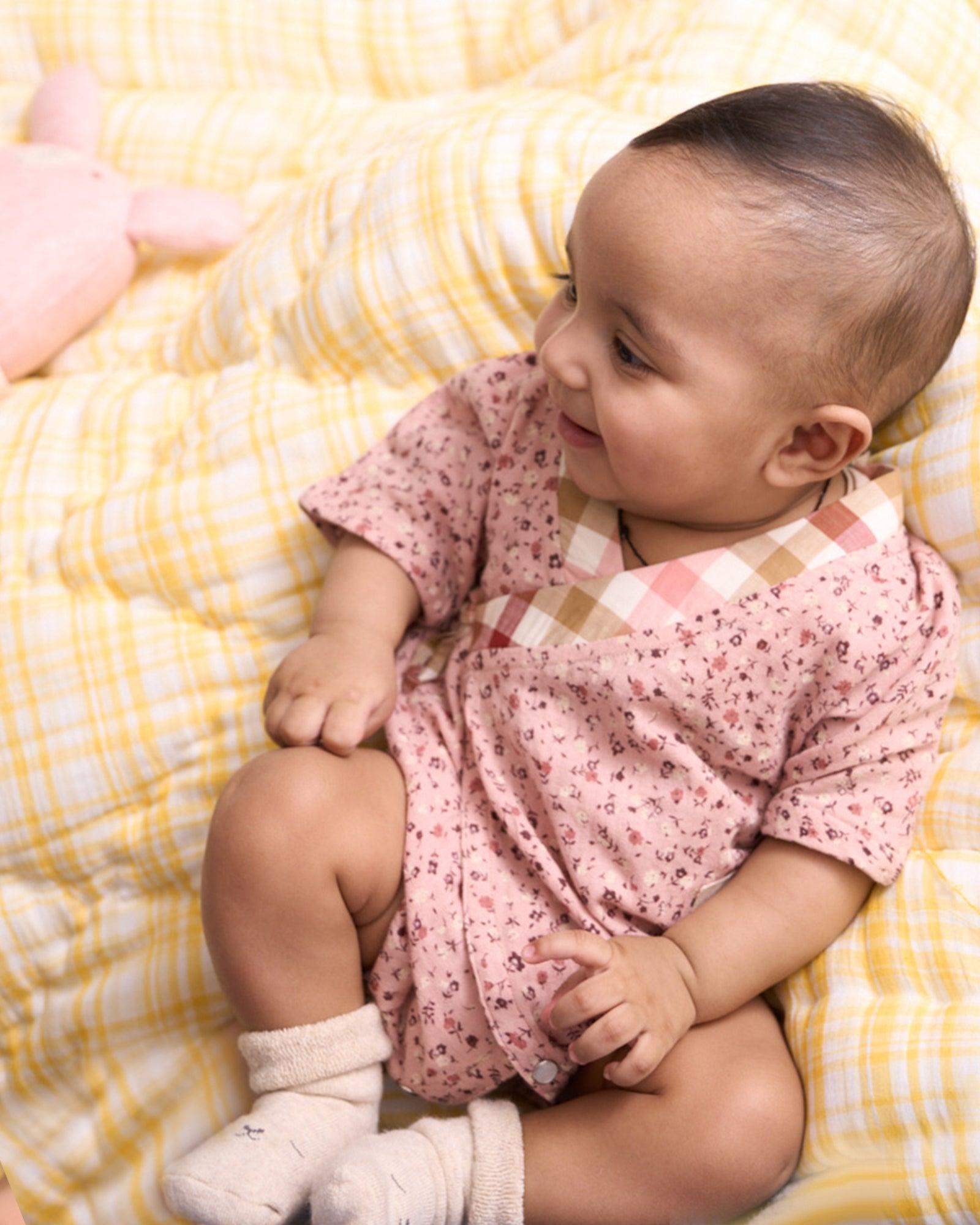 Baby cotton romper size chart by LAAD India – pink floral wrap-style bubble romper with checkered neckline. Adjustable straps for comfort . This baby romper is perfect everyday wear