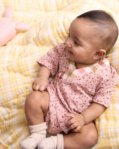 Baby cotton romper size chart by LAAD India – pink floral wrap-style bubble romper with checkered neckline. Adjustable straps for comfort . This baby romper is perfect everyday wear