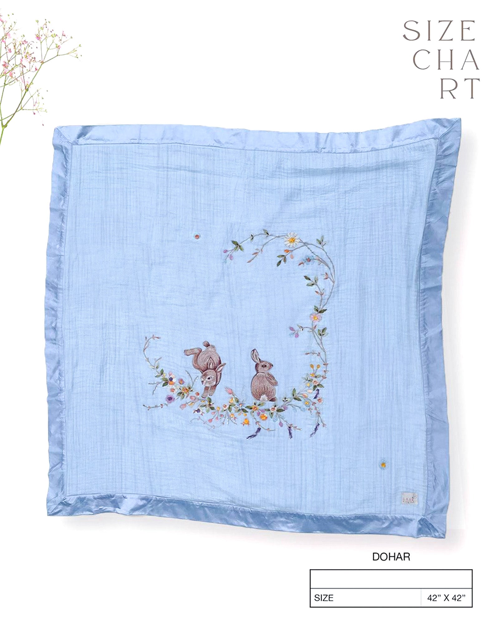Soft fairytale blue bunny dohar for baby with delicate embroidery featuring two bunnies surrounded by a floral wreath. Made from lightweight, breathable fabric with a satin border—perfect for cozy naps and gentle on baby’s skin.