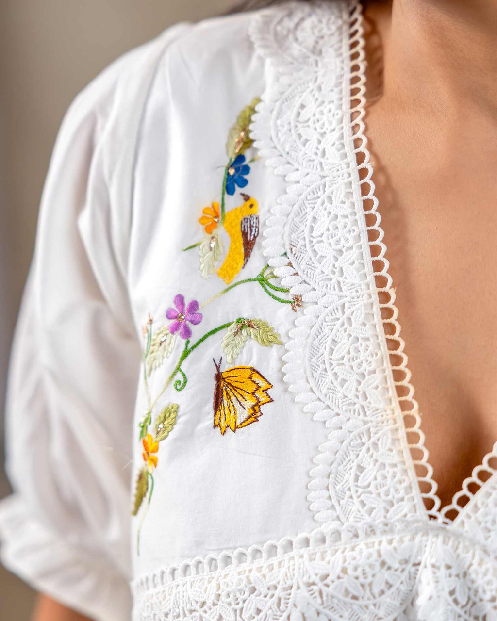 Woman wearing laad`s  white cotton midi dress with floral embroidery, scalloped neckline, and ruffled hem