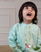 laad`s kid in short kurta featuring a bandhgala collar, hand-embroidered featuring bambi. Paired with ivory pants.