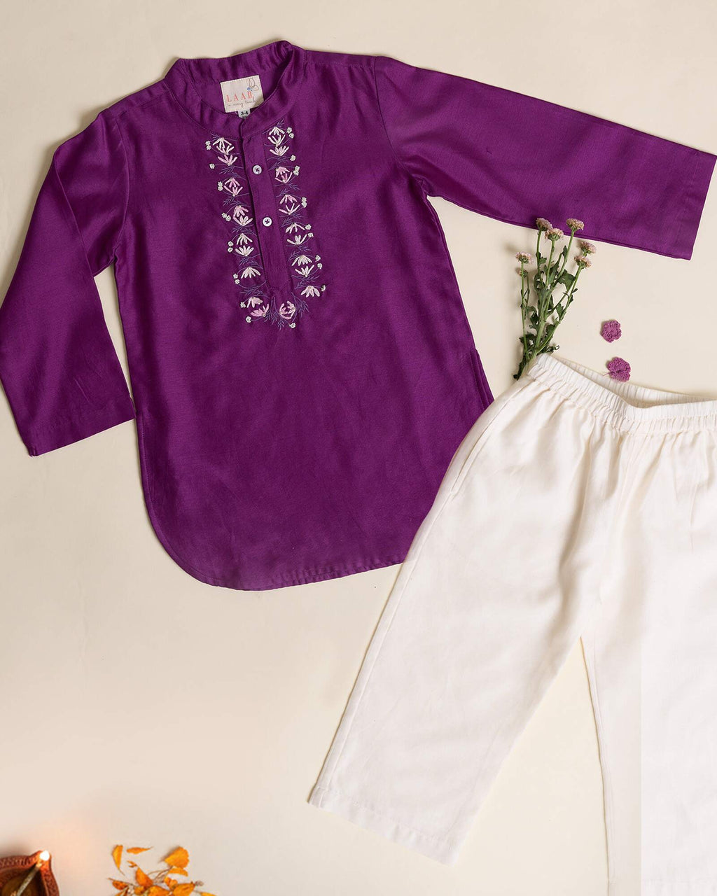 laad`s kid in japanese voilet kurta with embroideret  details on placket, paired  with off white trousers.