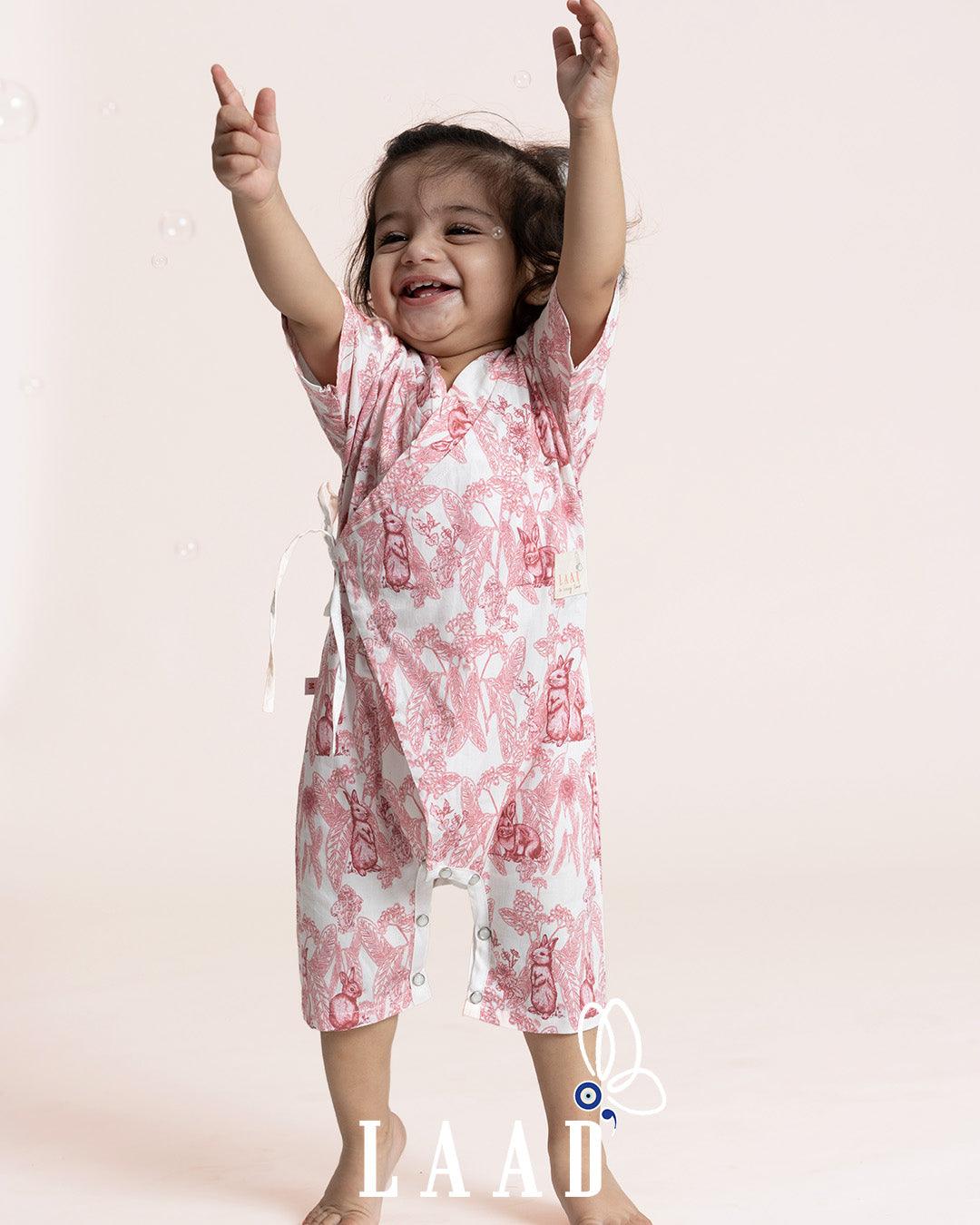 A premium cotton Kimono Romper with a whimsical bunny wonderland print in soothing pink tones. Featuring side tie closures for easy dressing and snap buttons at the crotch for quick diaper changes, this wrap-style romper offers a snug and adjustable fit. Made from 100% natural cotton