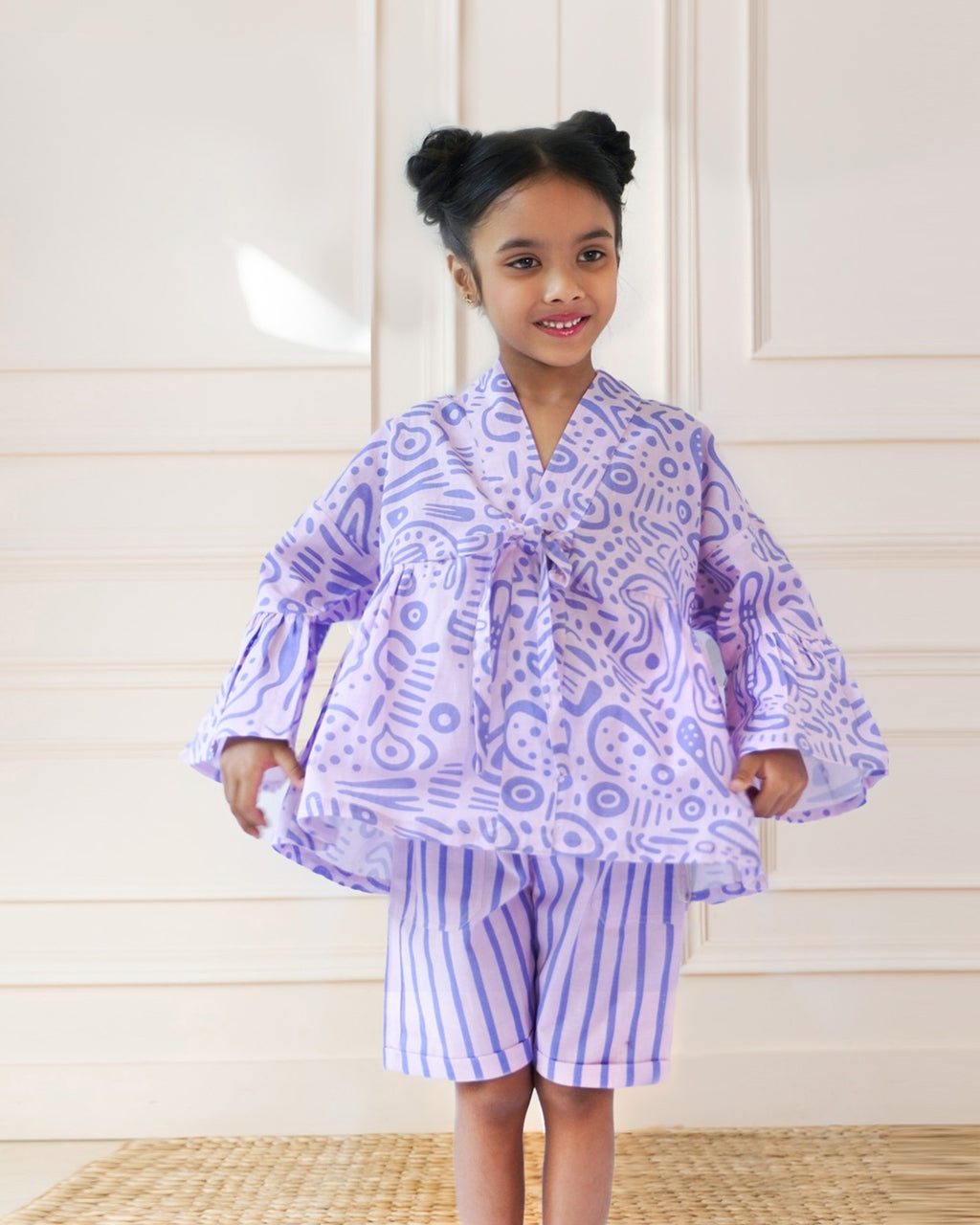 Laad`s girl  wearing a lilac kimono ameba co-ord set with abstract print top and striped shorts, stylish summer kidswear from LAAD India.